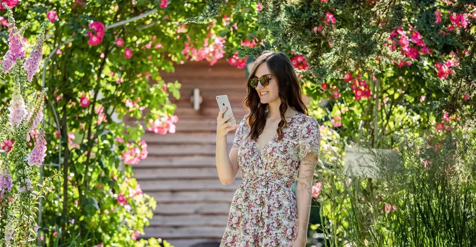 Frau mit Smartphone im Garten